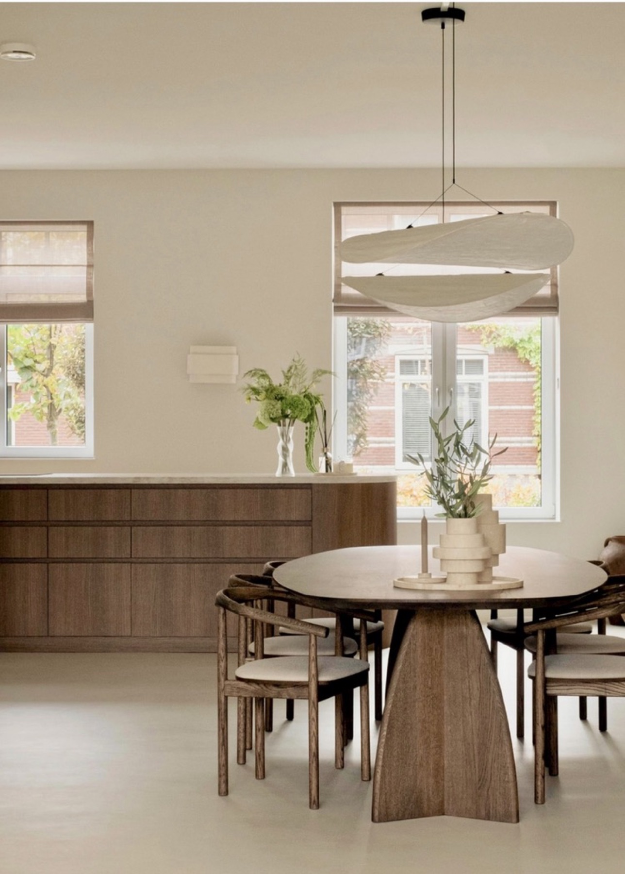 Eetkamer met ovale eikenhouten tafel, houten stoelen en linnen hanglamp